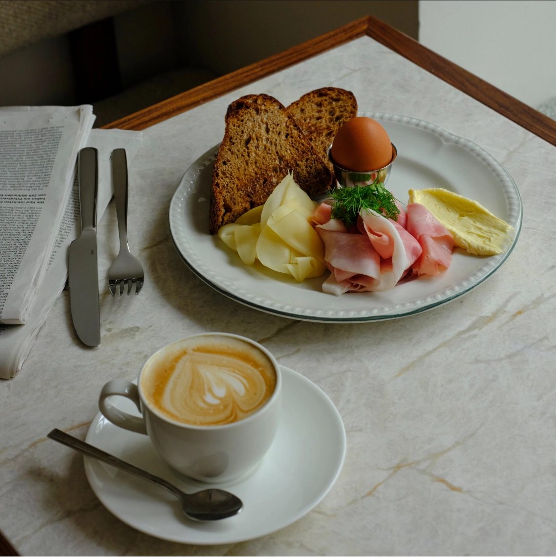 Frühstücksteller mit Ei, Schinken und Cappuccino in der Tagesbar Florentine München