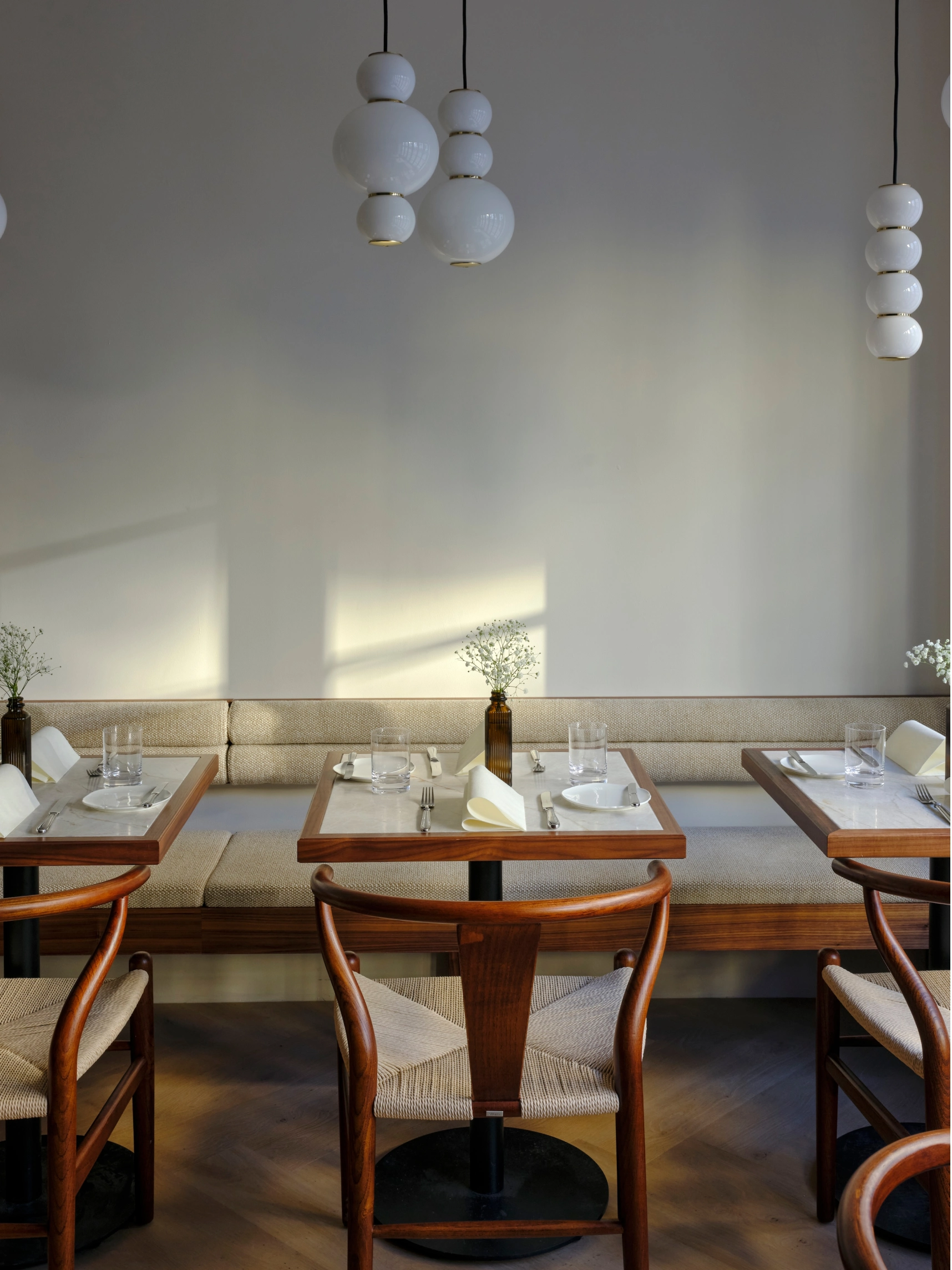 Eleganter Innenraum der Tagesbar Florentine München mit Designerlampen und Holzmöbeln