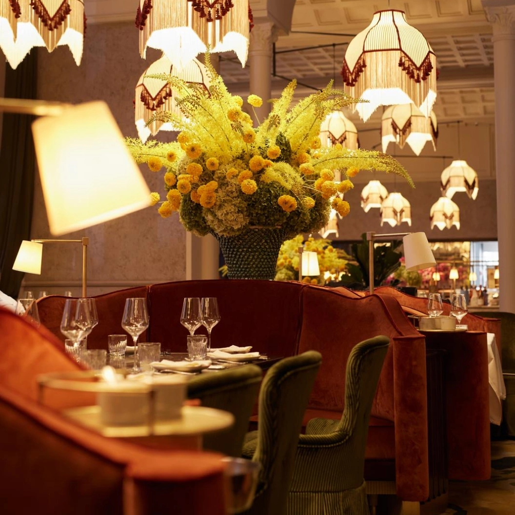 Blumenarrangement und gemütliche Sitzecke im Restaurant Pellicano München