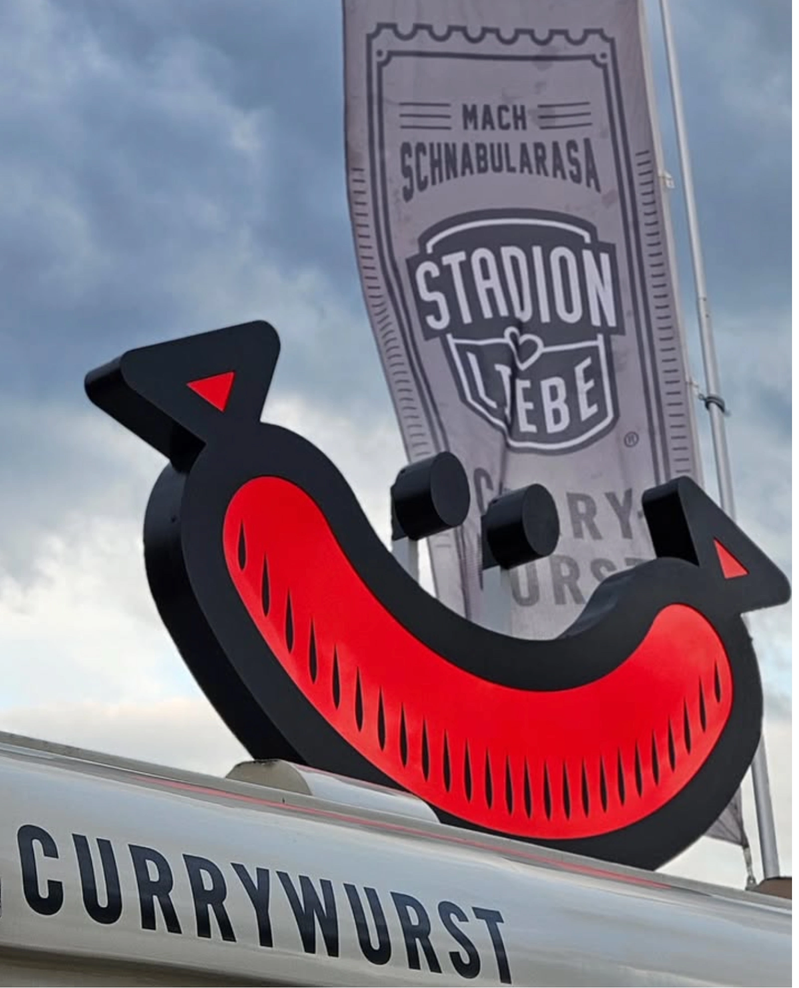 Aussenschild mit Logo und Chili-Maskottchen des Food-Startups Stadionliebe München