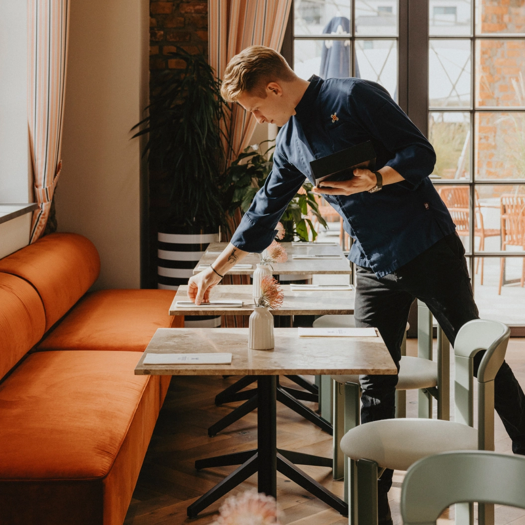 Kellner beim Eindecken der Tische in der Brasserie Turbinenhaus München
