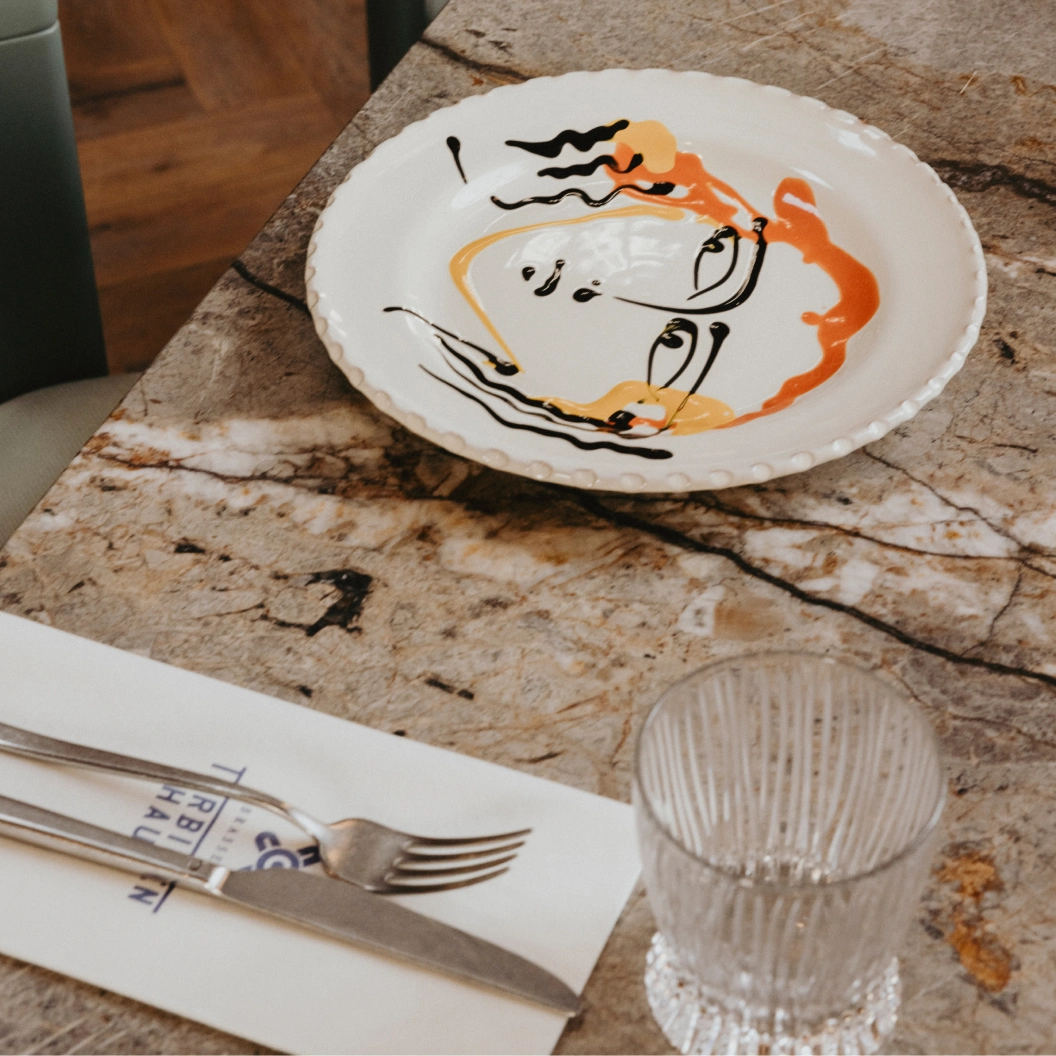 Handbemalter Teller auf Marmortisch in der Brasserie Turbinenhaus München